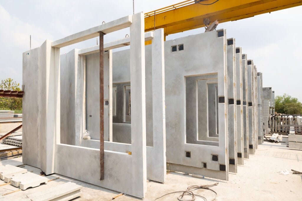 Precast concrete wall panels stacked in a manufacturing or construction yard.