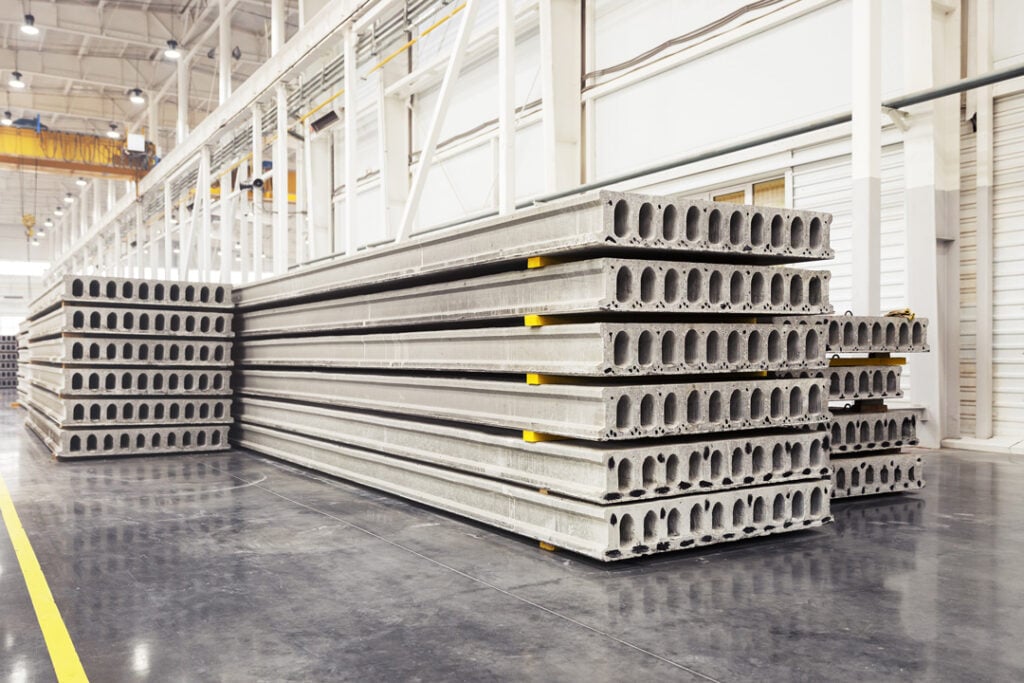 A large industrial warehouse or factory, showing stacks of precast concrete construction slabs.