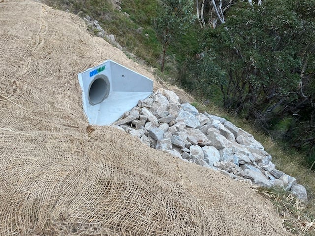 culvert outlet on guthega rd featuring a concrete headwall, rock riprap, and jute erosion control