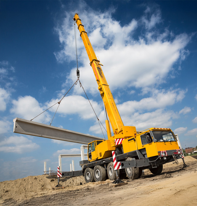 Mobile crane lifting concrete beam during construction project by South East Civil & Crane.